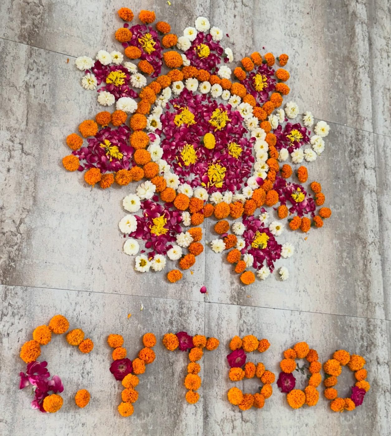 A mandala of marigold flowers laid on the floor